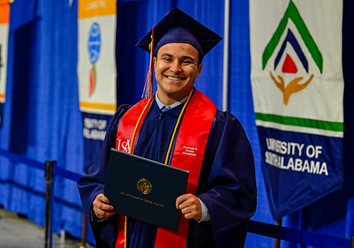 New graduate holding diploma.