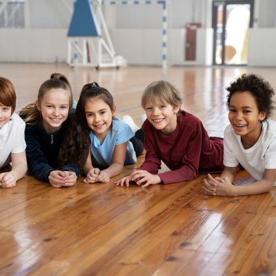 Kids laying on their stomach on the floor.