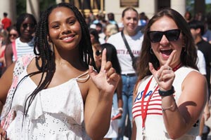 Two students holding up J's at convocation.