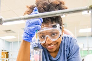Student working in chemistry lab with beaker.