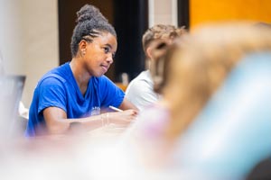 Students working at desk in classroom.