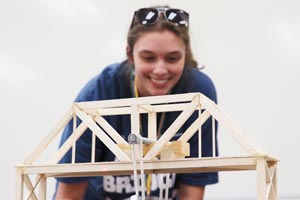 Student working on bridge model in engineering.