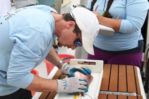 Marine Sciences student studying snapper fish on boat.