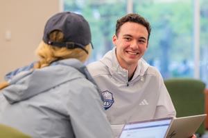 Two students talking in MCOB library.