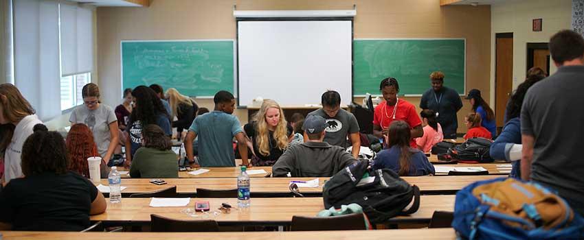 Professor lecturing students about the effects of parenting and pregnancy.