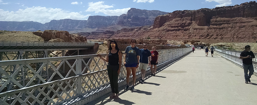 Geology students on a bridge with a mountain view.