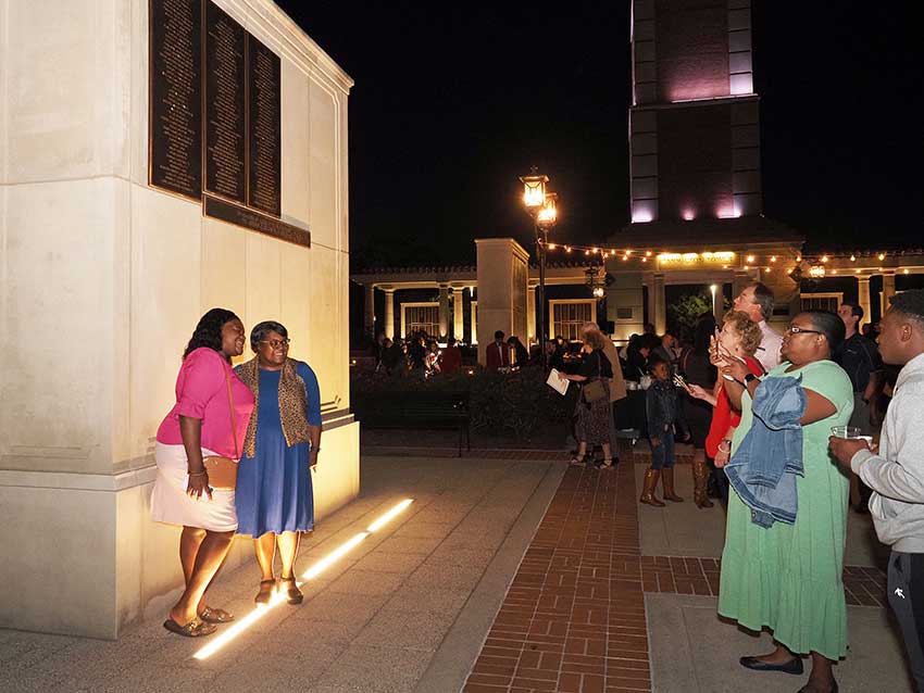 People standing in front of Moulton tower posing for picture.