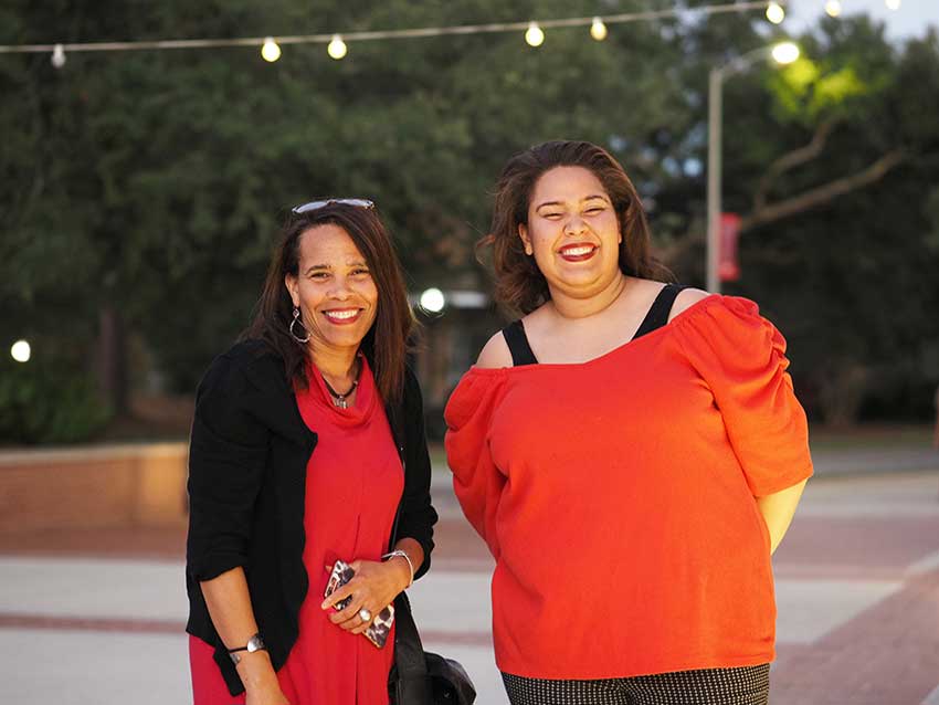 Two women smiling at ceremony.