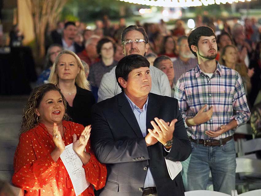 Crowd clapping at ceremony.