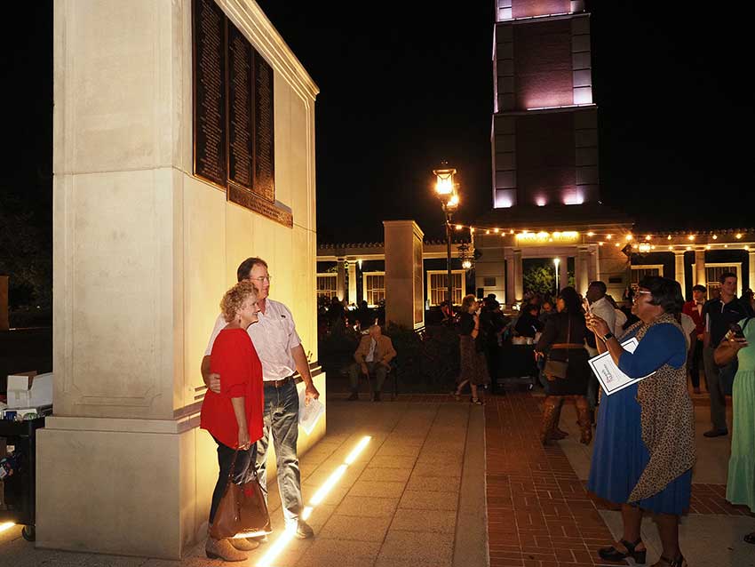 People standing in front of Moulton tower posing for picture.