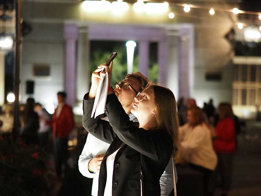 Woman holding up phone taking picture.