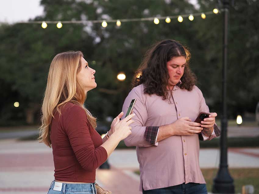 Two people with phones at ceremony.