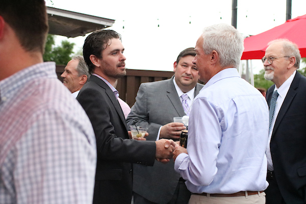 Man shaking another man's hand at event.