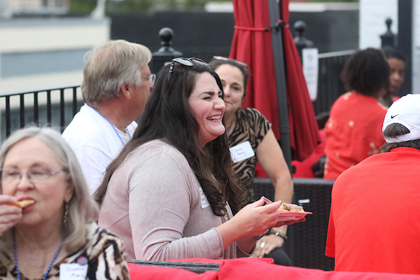 Woman speaking to group on patio.