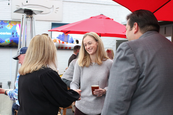 Three people speaking at event.