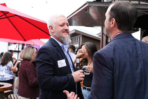 Man with beard speaking to someone.