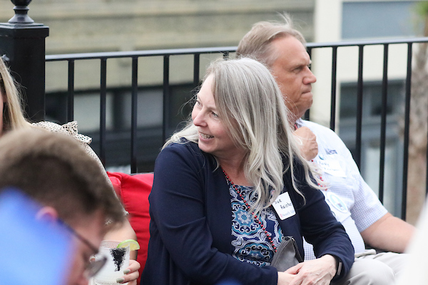 Woman leaning sideways to listen to someone.