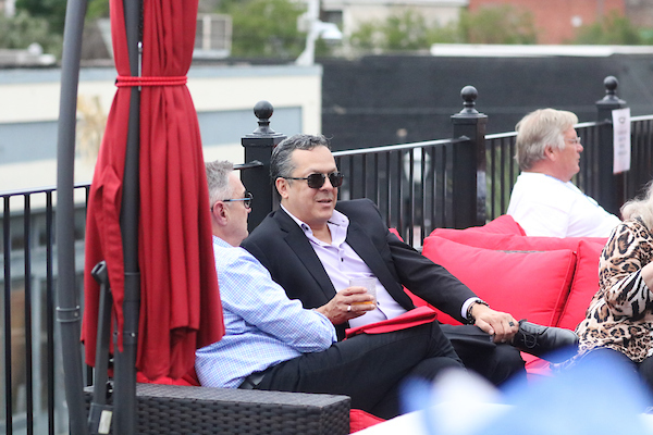 Man in sunglasses sitting on couch outside.