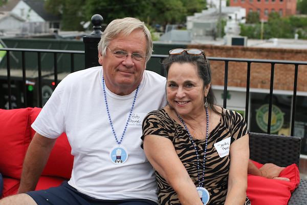 Woman wearing jaguar print shirt sitting next to man,