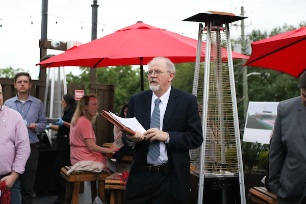 Man holding paper speaking.