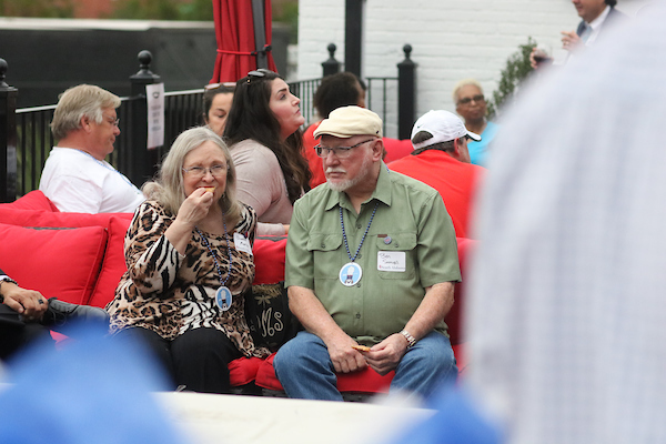 Woman eating sitting next to man on outside patio.