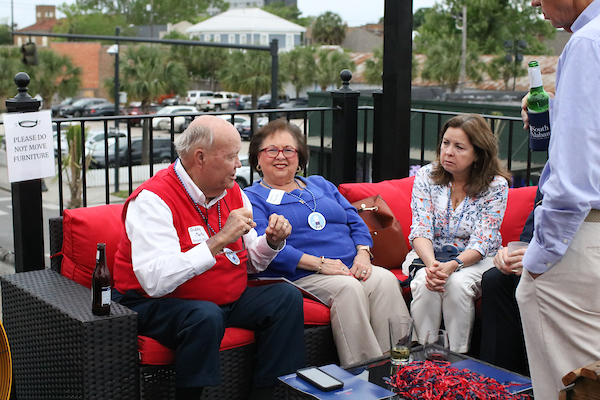 Man sitting with alumni on outside patio.