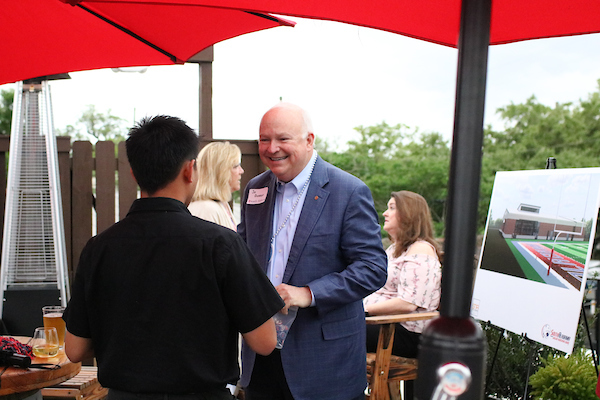 President Bonner speaking with alumni under tent.