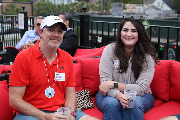 Man in red shirt sitting with woman.