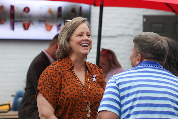 Woman in jaguar print shirt smiling.