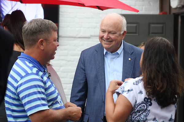 President Bonner talking to man in striped shirt.