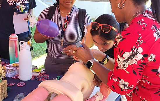 Students working with a dummy on a table with oxygen mask.