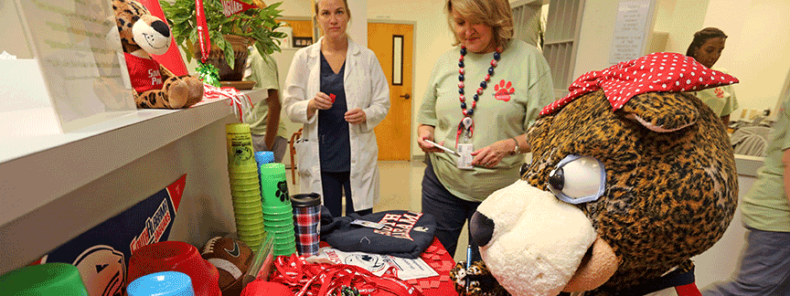 Ms. Pawla at the Student Health desk with nurses behind her.