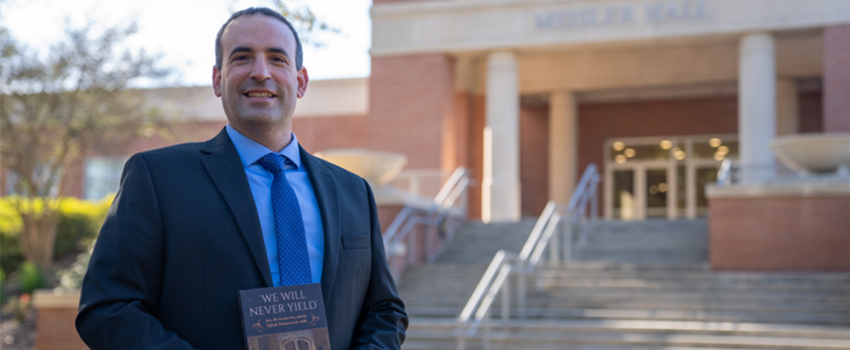 Dr. David Meola holding a book.