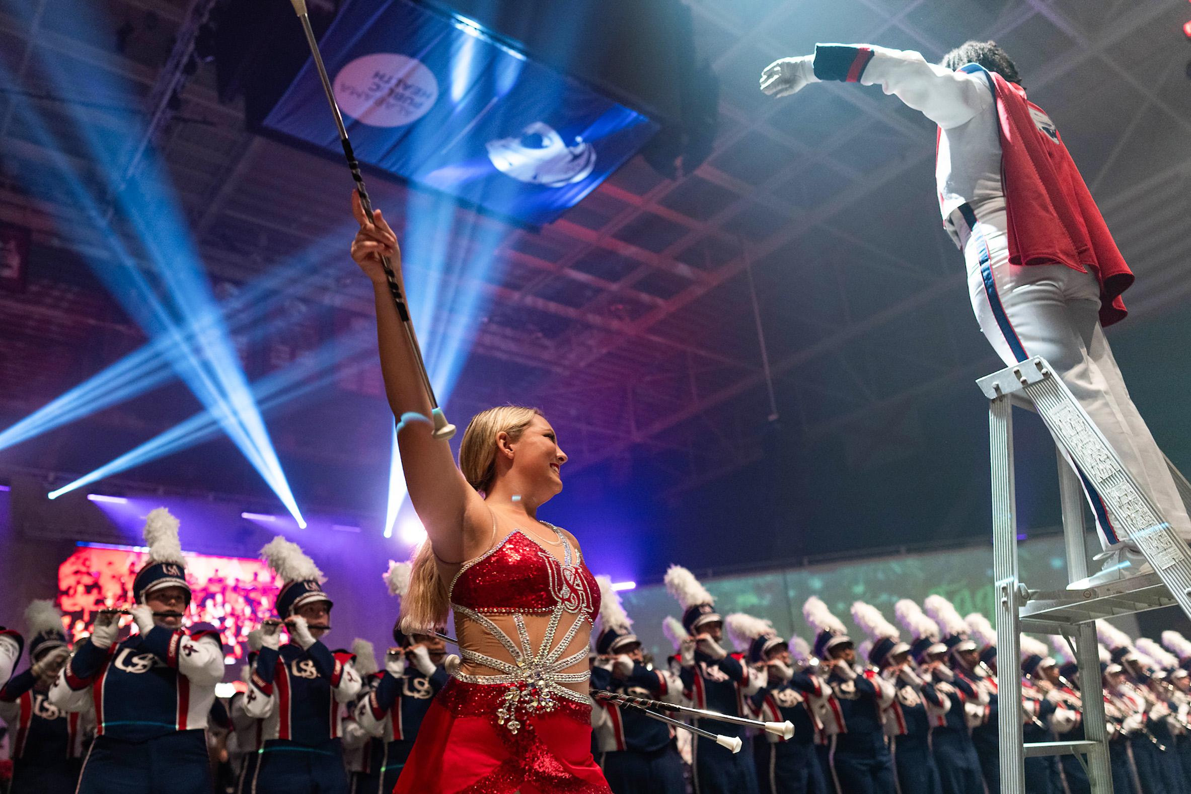 Twirler in front of marching band.