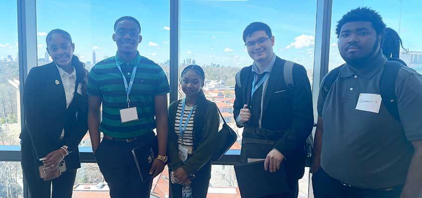 Group of students in front of window.