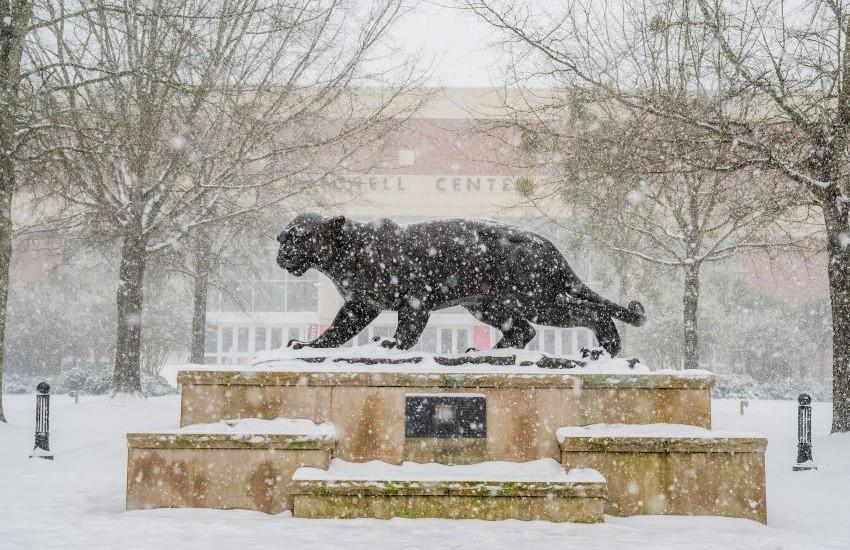 Jaguar statue with snow falling.