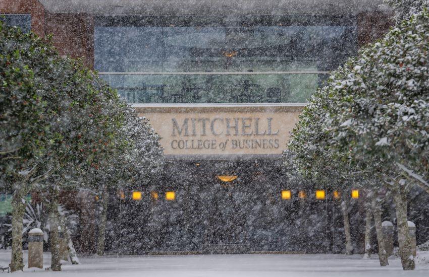 Mitchell College of Business with snow falling.