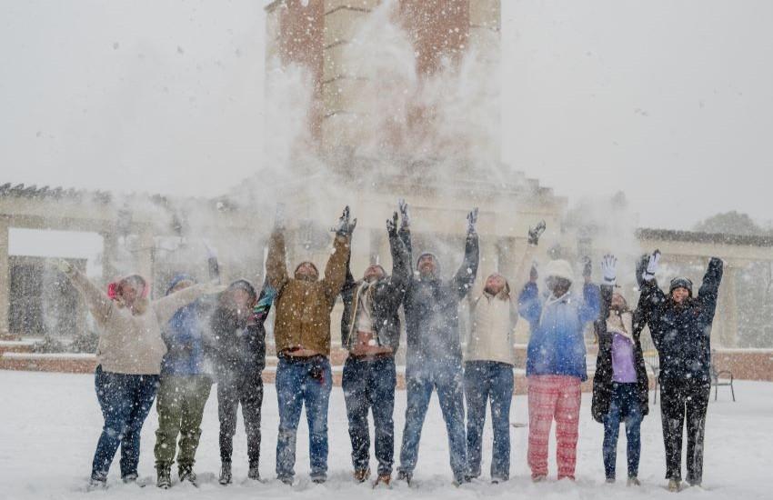 Students throwing snow up in the air in front of Moulton Tower.