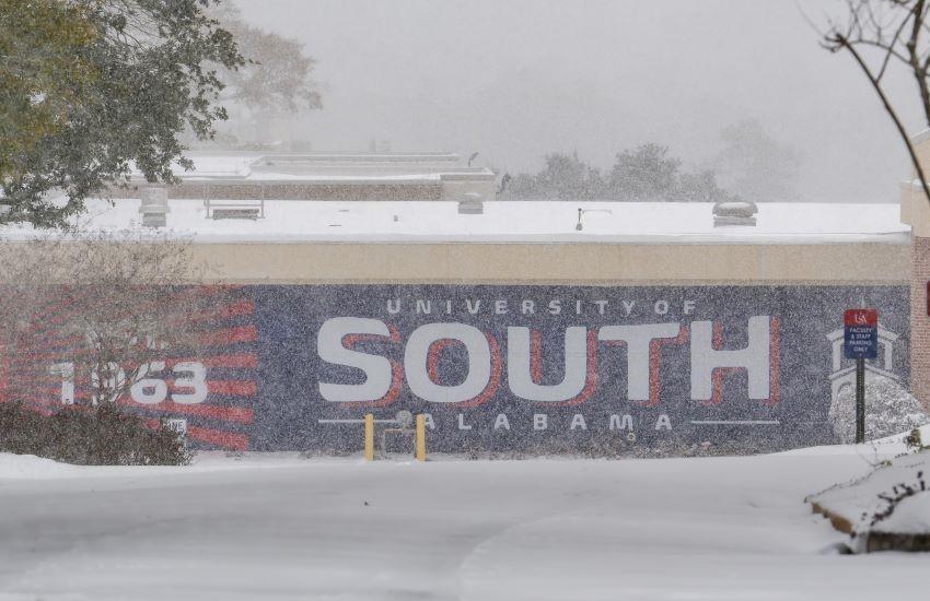 Campus mural in background while snowing.