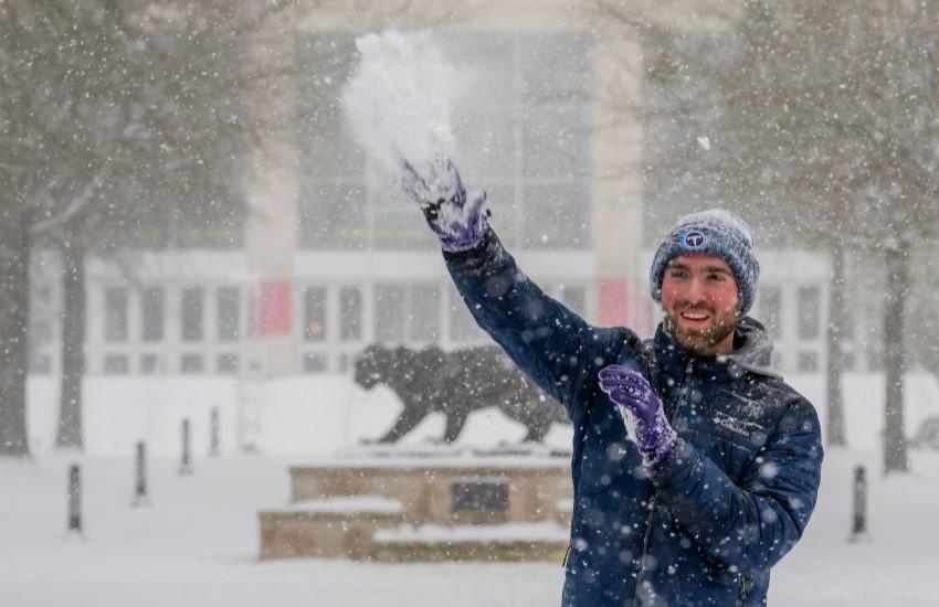 Student throwing snow into the air.