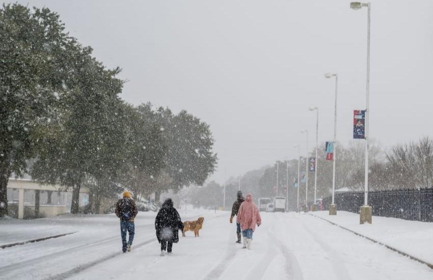 Group walking down street on campus in snow.