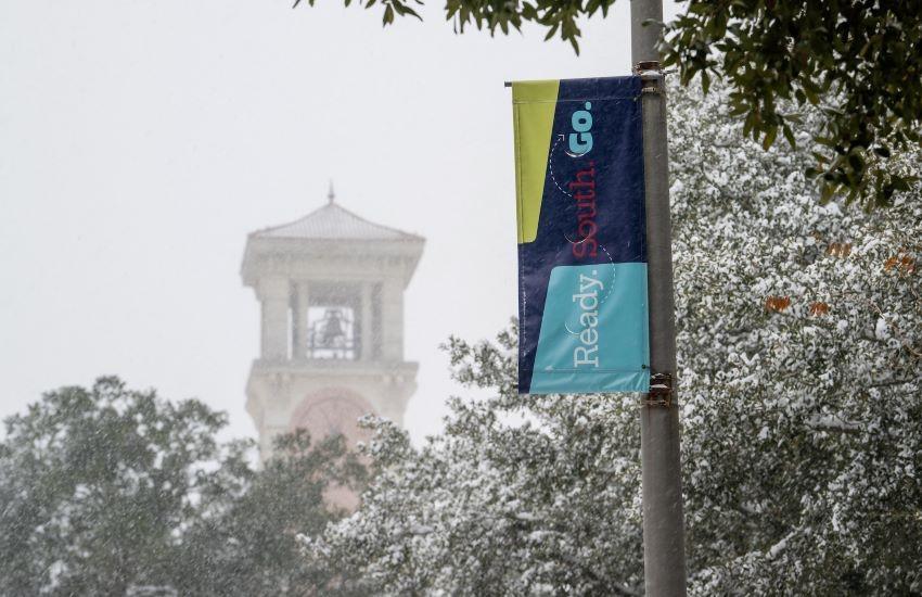 Moulton tower and street flag with snow falling.