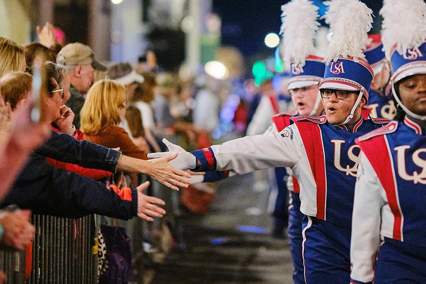 Jaguar Marching Band giving high fives to audiences