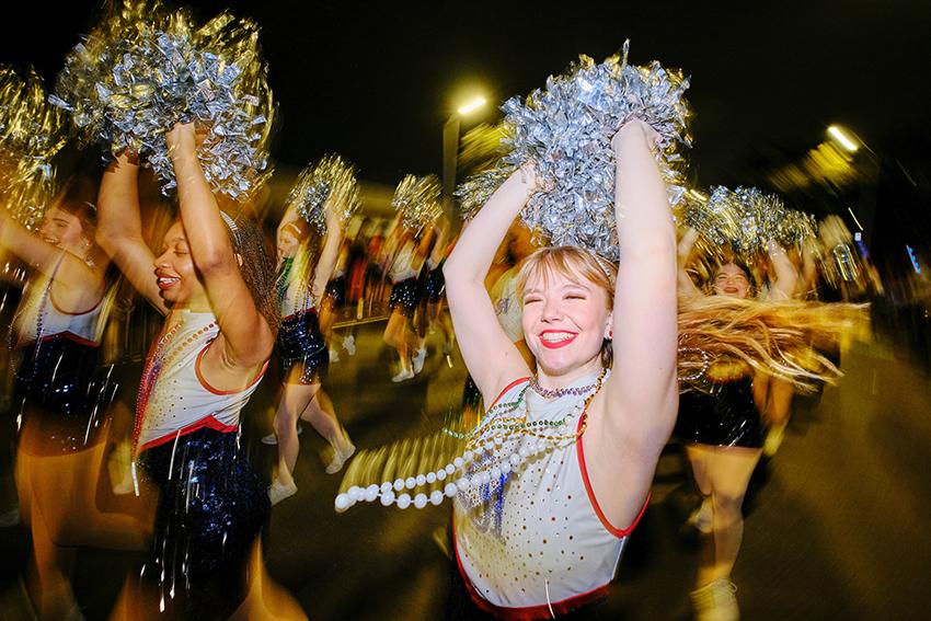 Cheerleaders raising their pompoms up 