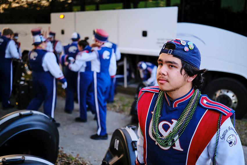 Guy with Jaguar Marching Band uniform and beads in Mardi Gras celebration