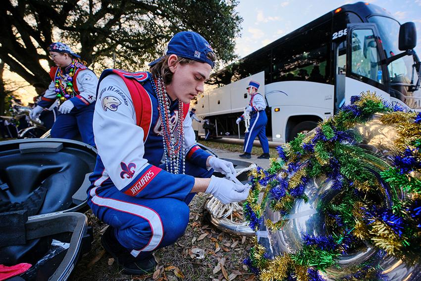 Jag Marching Band decorating his instrument with Mardi Gras decoration