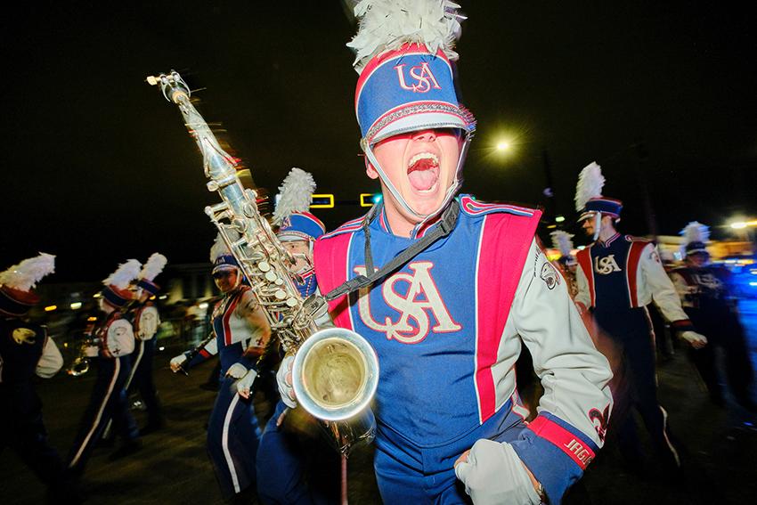 Jaguar Marching Band holding up his Saxophone while smiling