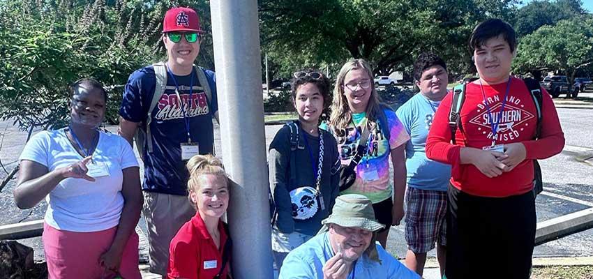 PEP students on campus by flag pole.