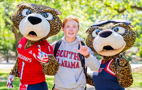 Student holding up J sign with Southpaw and Ms. Pawla.