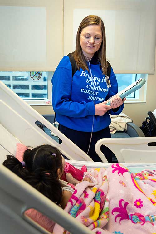 Tillman working with child in bed at hosptial.